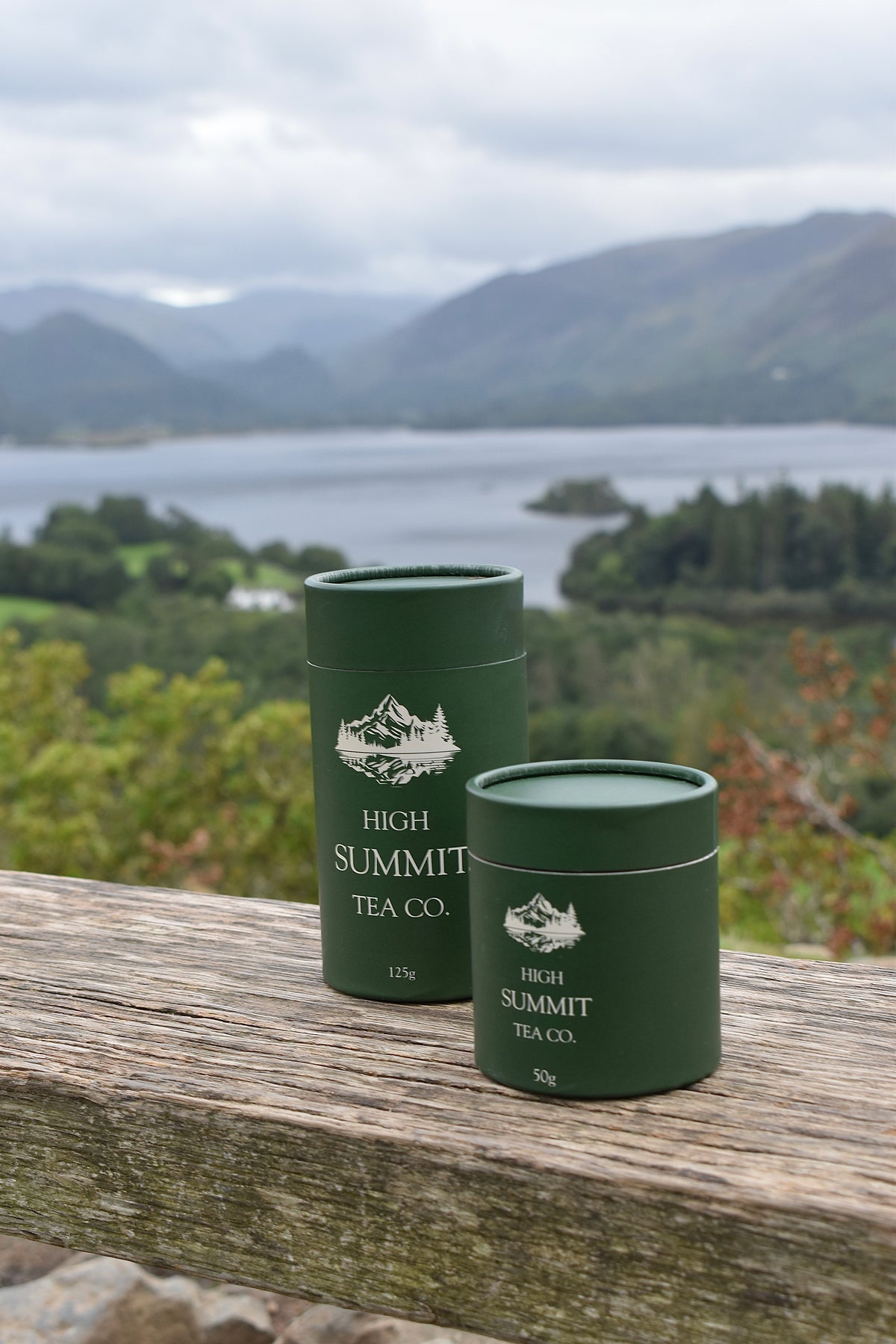 Two dark green cylindrical tea tubes labelled High Summit Tea Co. 