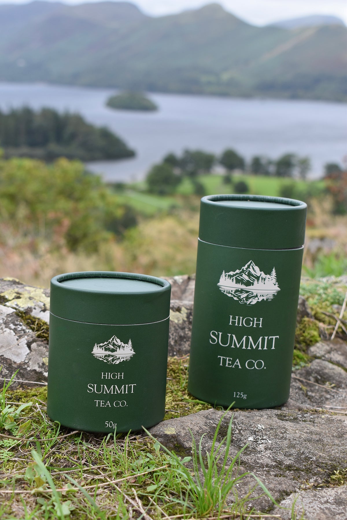 Two dark green cylindrical tea tins labelled High Summit Tea Co.